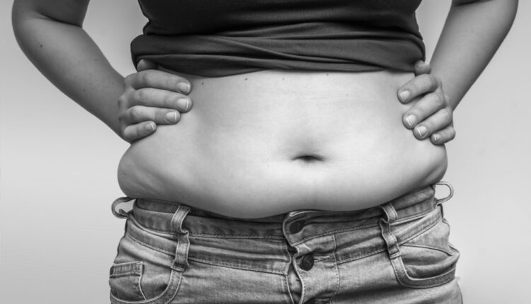 Overweight woman in jeans and fat on hips and belly